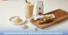 A clean display of health and beauty products made from cricket protein, featuring powder, a protein bar, capsules, and a prepared protein shake on a wooden tray.